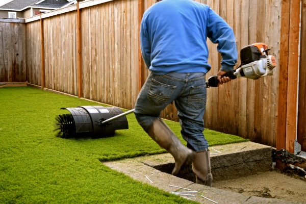 Workers,Installing,Artificial,Turf,In,A,Residential,Yard.